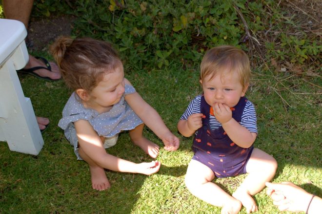 Ella plays the role of the pusher man introducing Nate to his first Cheerios.